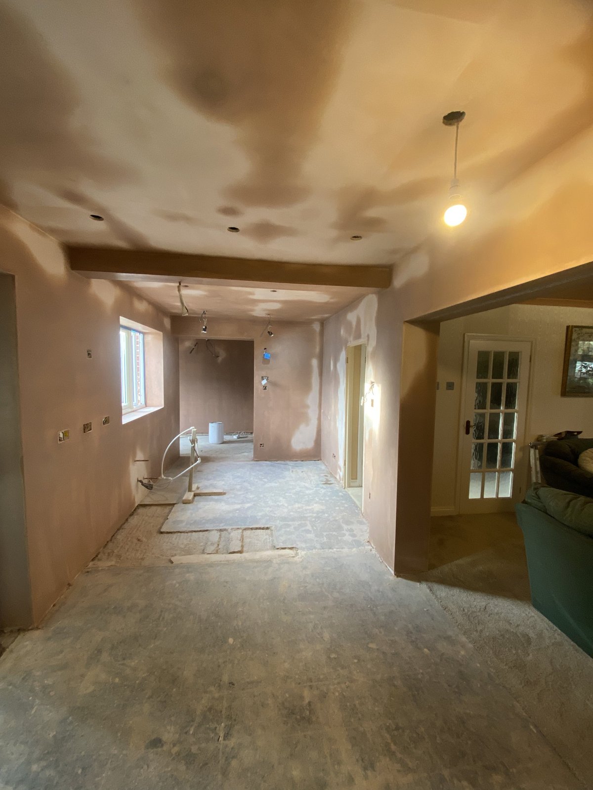 Interior of home under renovation with exposed drywall, concrete floor, and work-in-progress walls and ceiling